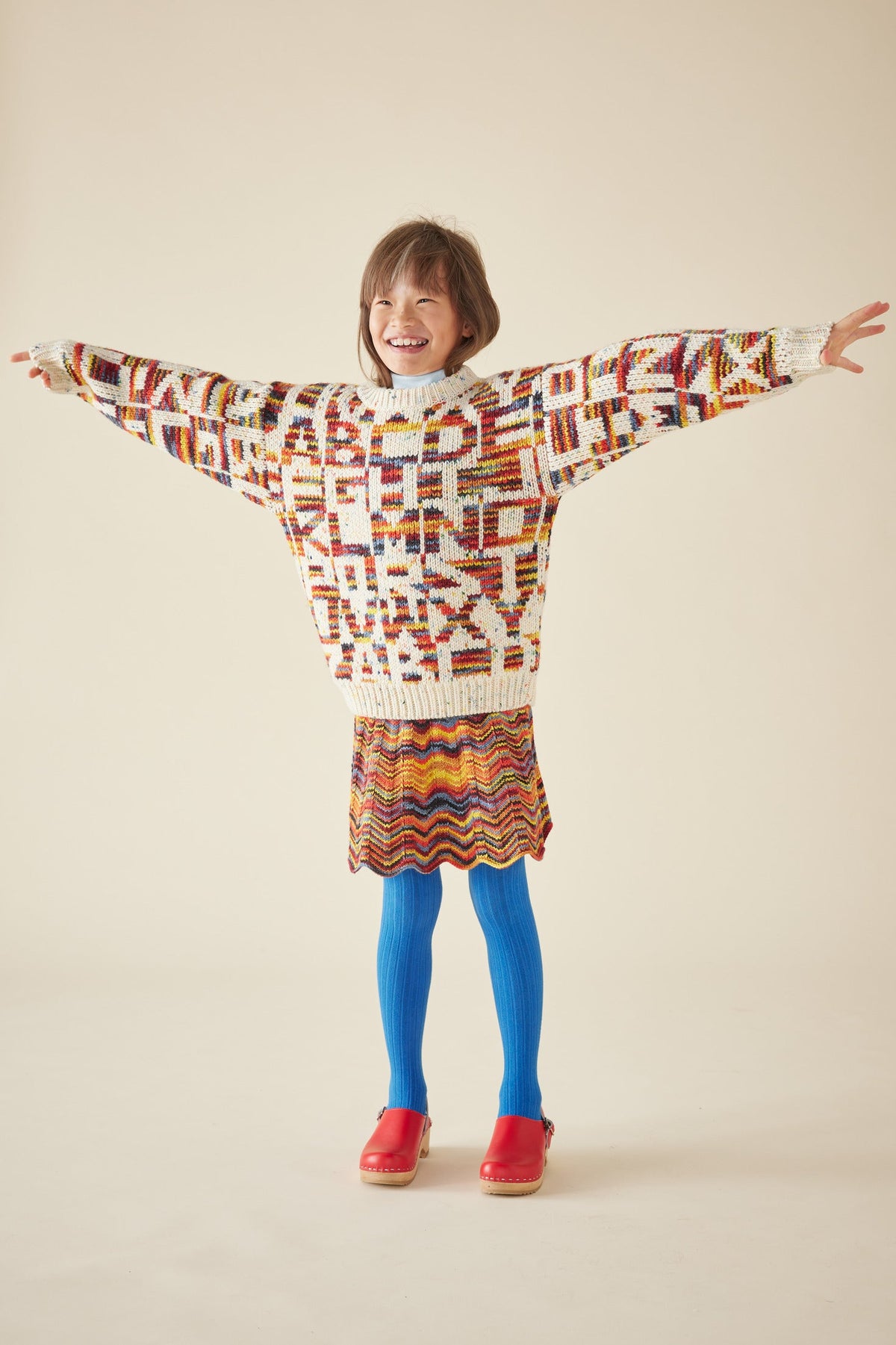 Alphabet Intarsia Sweater - Prime Confetti+Model is 51 inches tall, 51lbs, wearing a size 9-10y