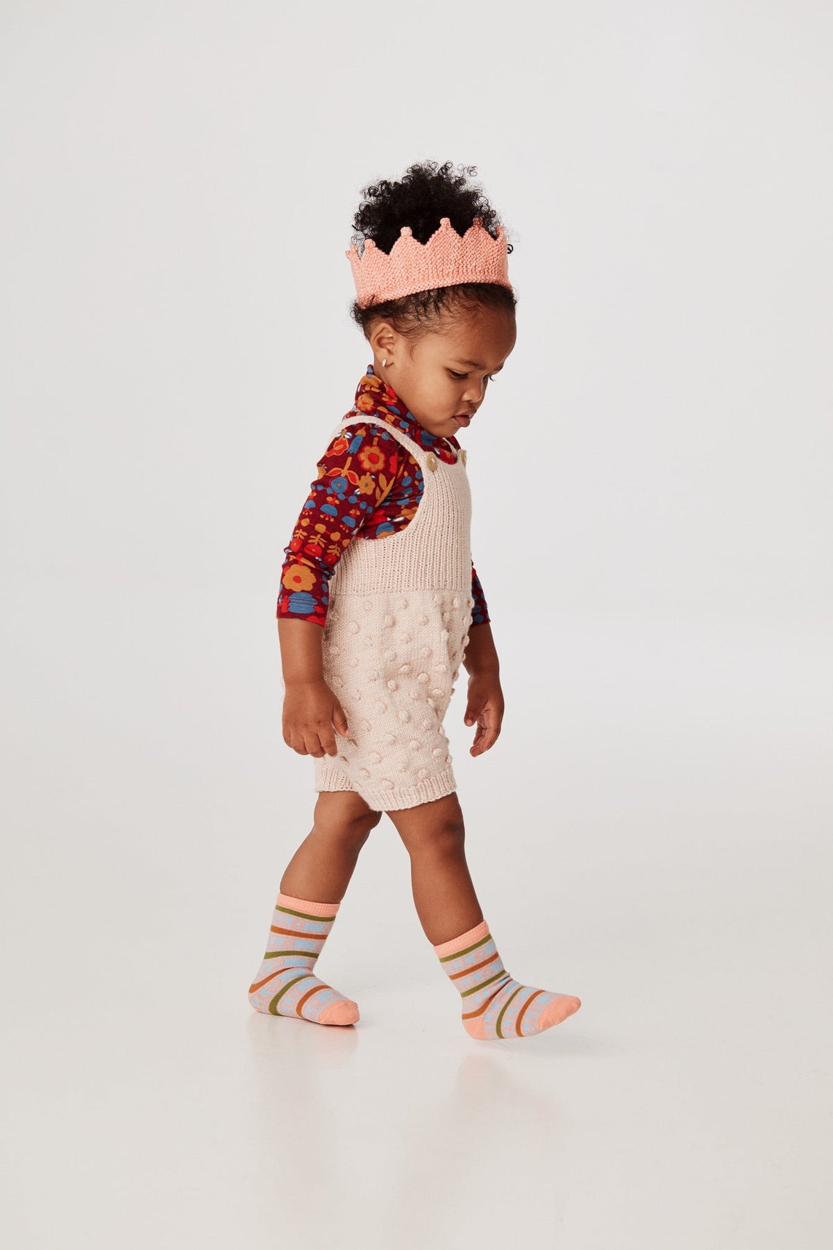 Popcorn Romper - Dune+Model is 32 inches tall, 25lbs, wearing a size 12-18m