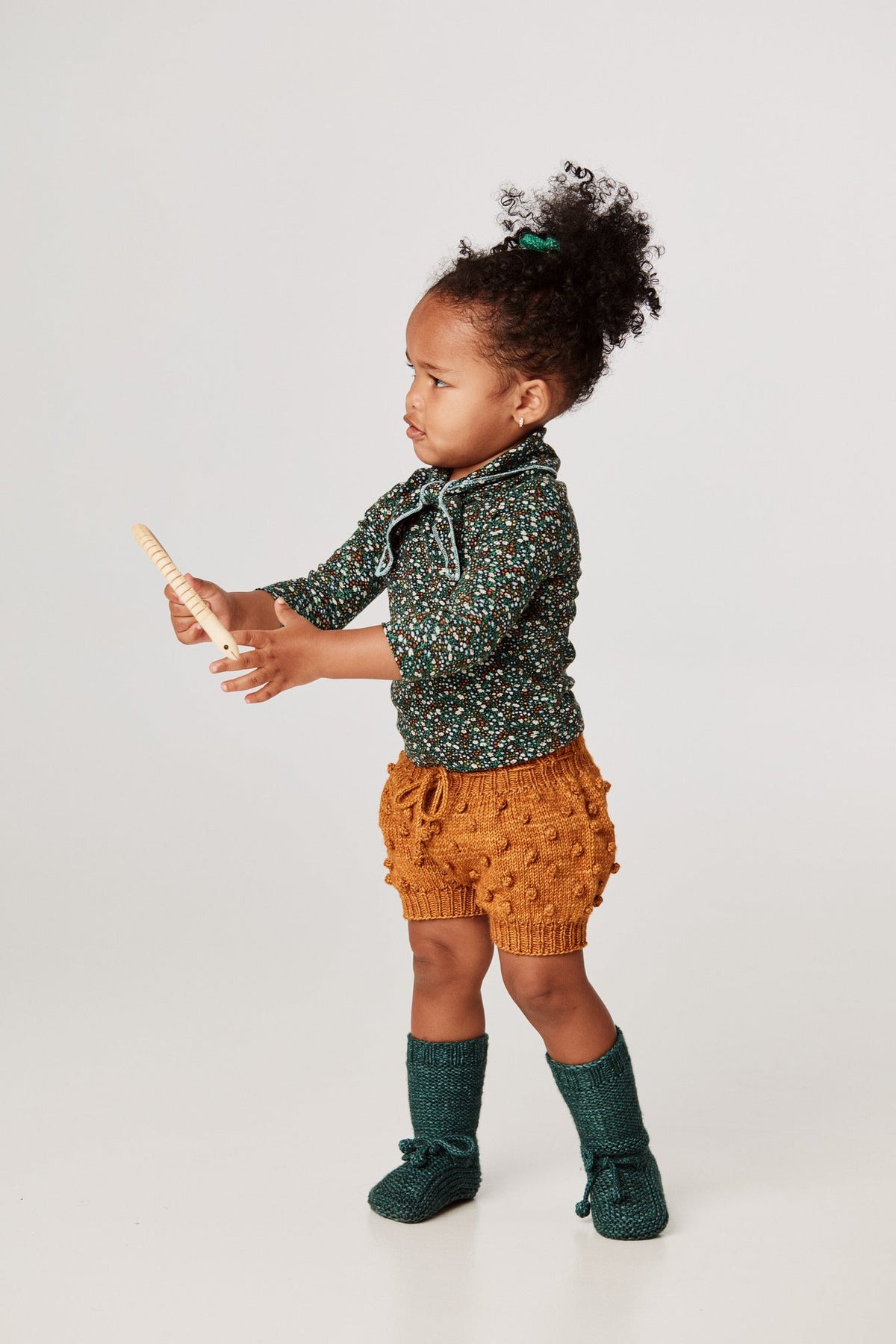 Scout Top - Emerald Mini Floral+Model is 32 inches tall, 25lbs, wearing a size 12-18m