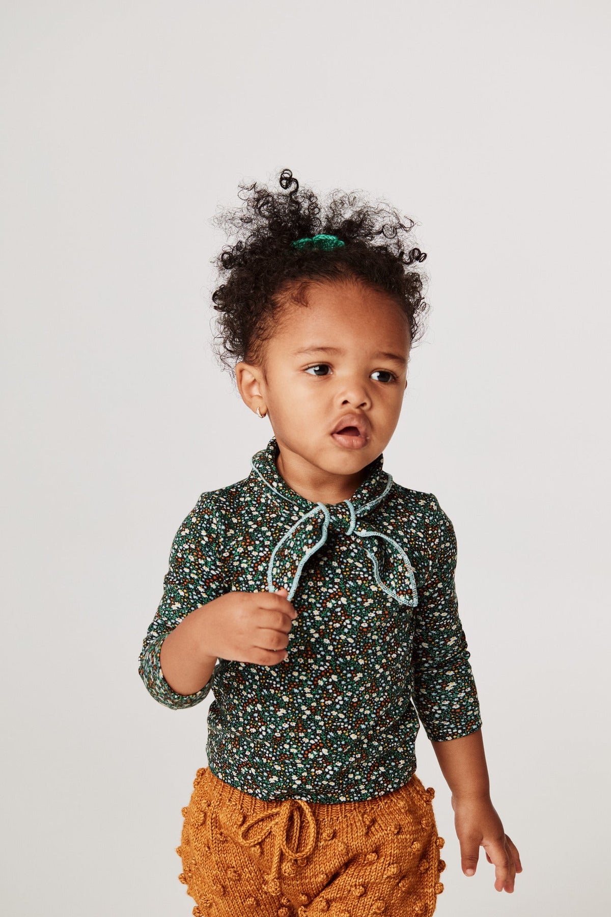 Scout Top - Emerald Mini Floral+Model is 32 inches tall, 25lbs, wearing a size 12-18m