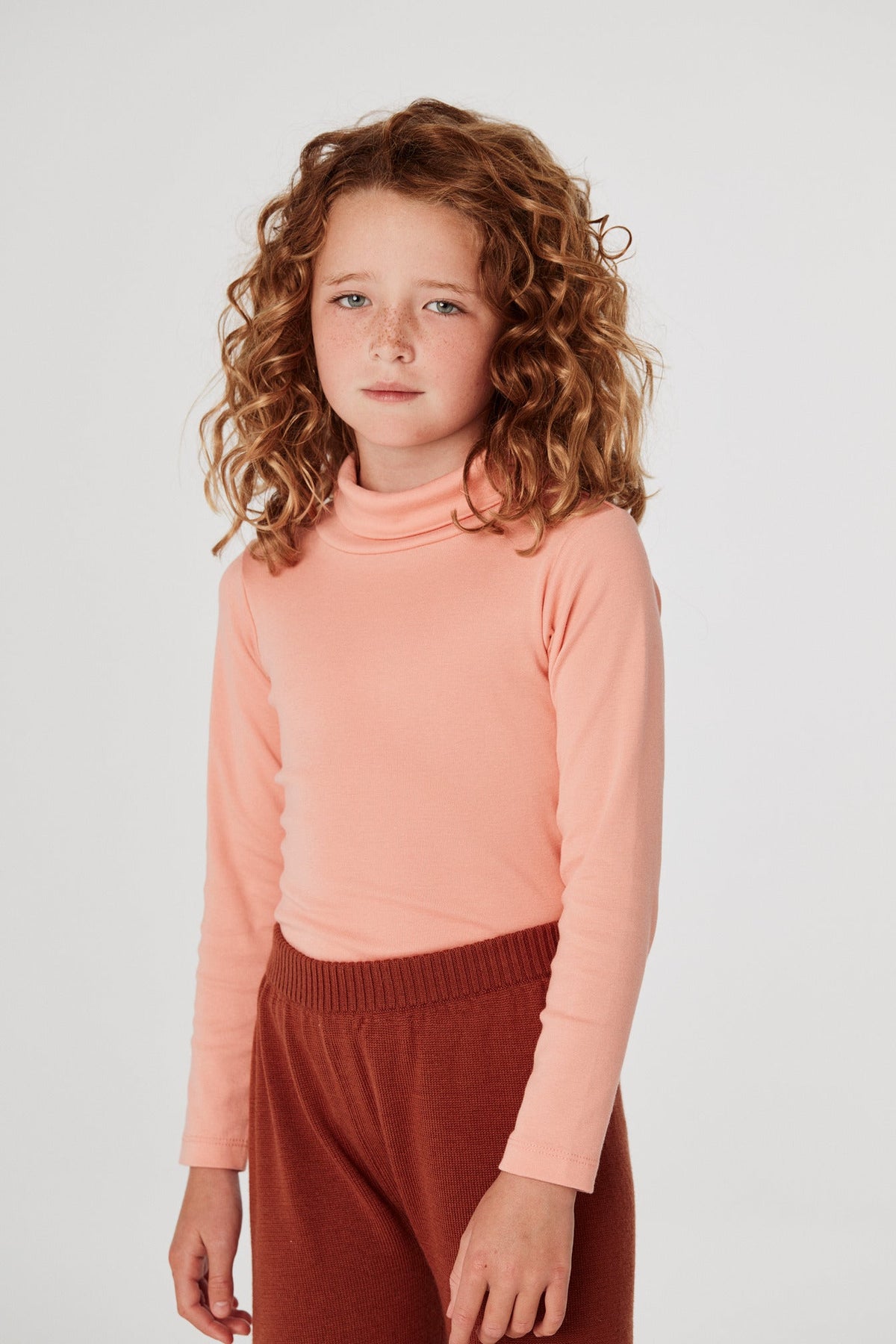 Turtleneck - Grapefruit+Model is 48 inches tall, 48lbs, wearing a size 6-7y