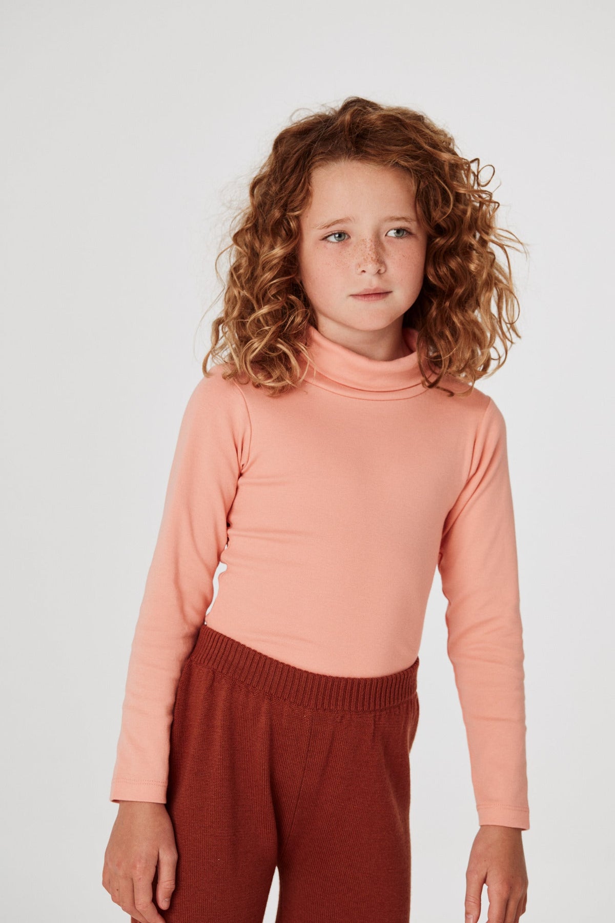 Turtleneck - Grapefruit+Model is 48 inches tall, 48lbs, wearing a size 6-7y
