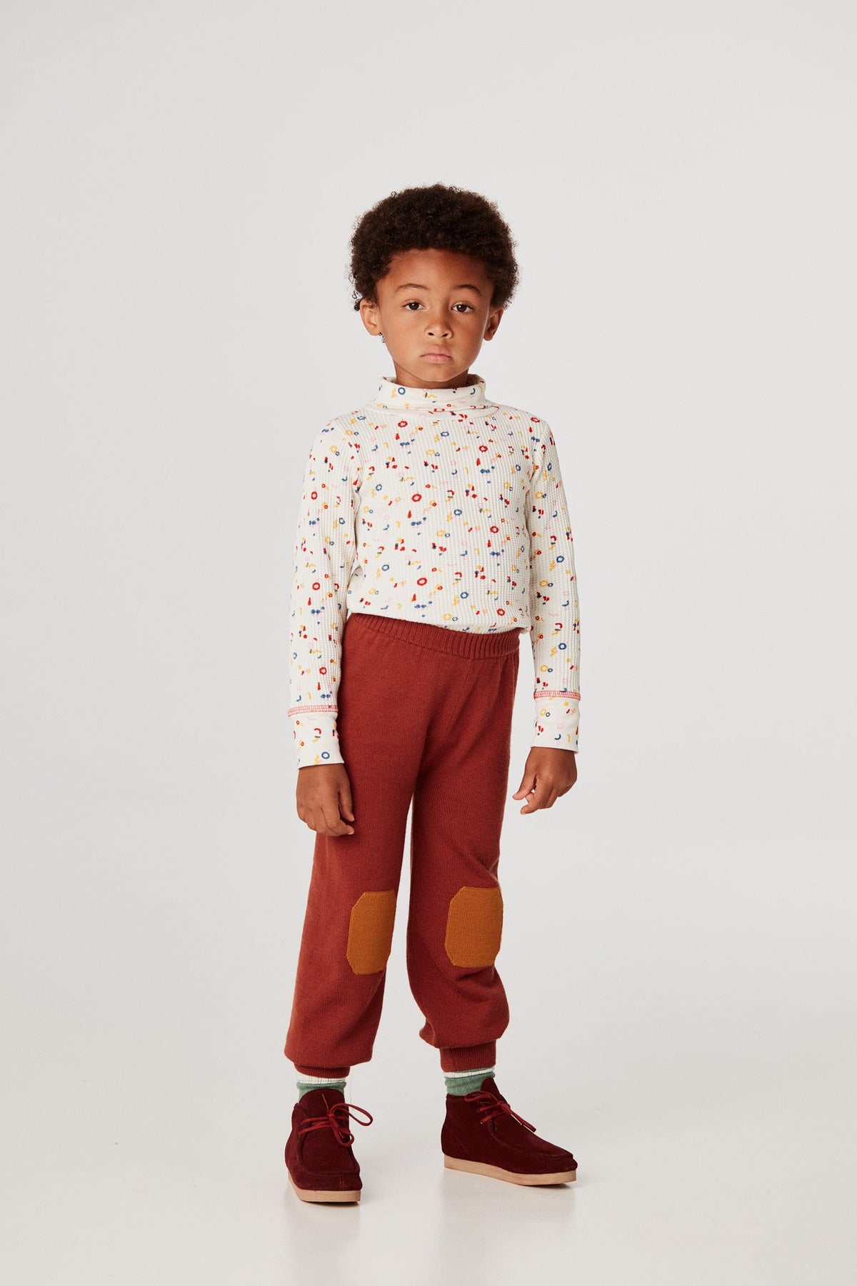 Waffle Turtleneck - Red Flame Shapes+Model is 45 inches tall, 46lbs, wearing a size 4-5y
